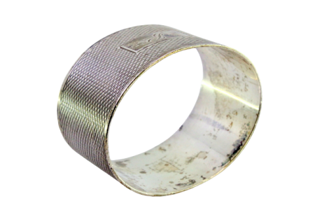 Argola de guardanapo em prata de forma oval guilhochada envolvendo cartela para monograma.